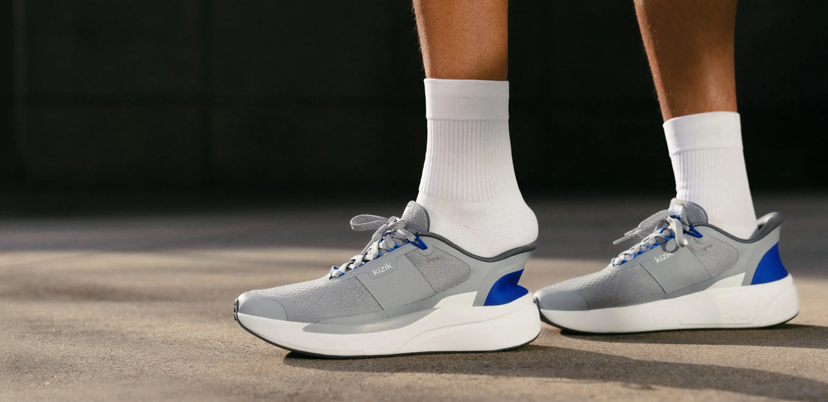 A person stepping into a pair of grey Kizik hands-free sneakers